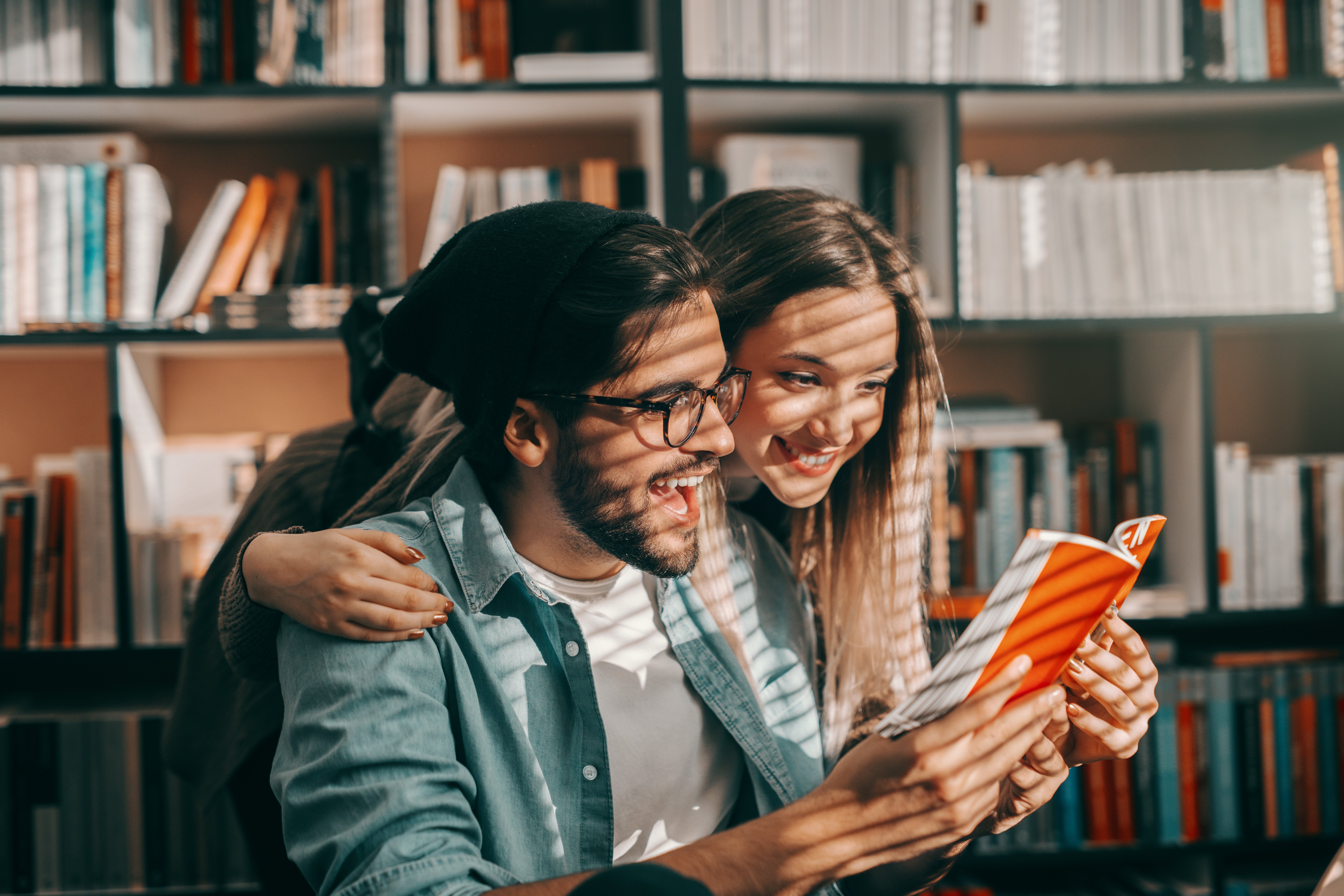 Junge Frau und Mann schauen gemeinsam in ein Buch Junge Frau und Mann schauen gemeinsam in ein Buch