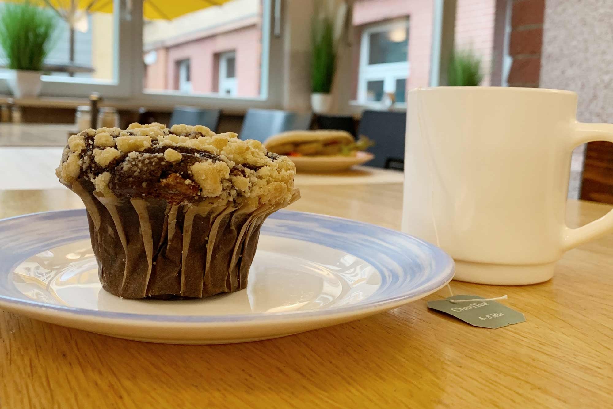Muffin auf Teller und eine Tasse Tee im Café Jungiusstraße