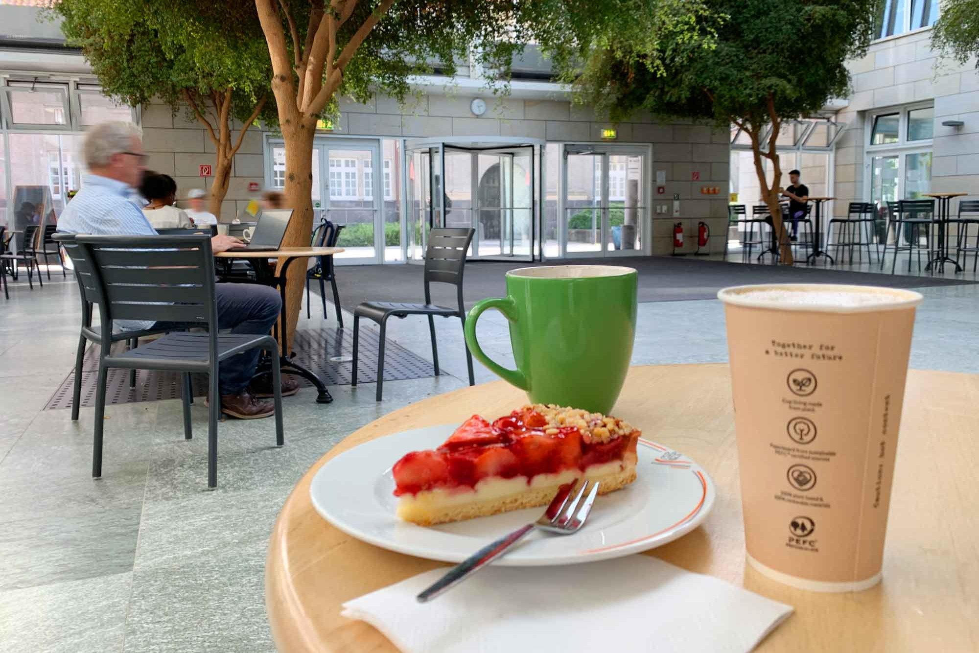 Kaffee und ein Stück Erdbeerkuchen auf einem Teller