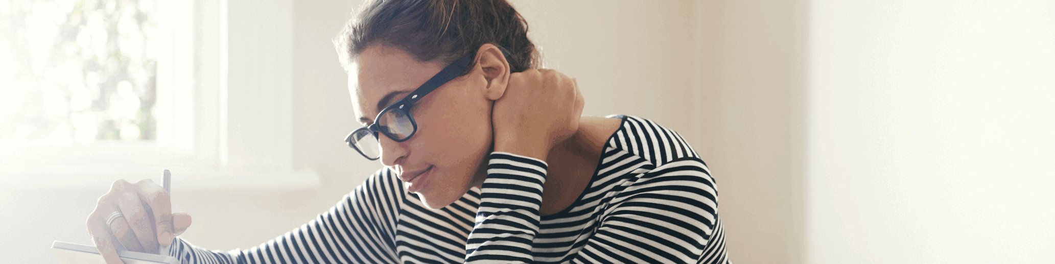 Woman sitting at a table in front of a tablet