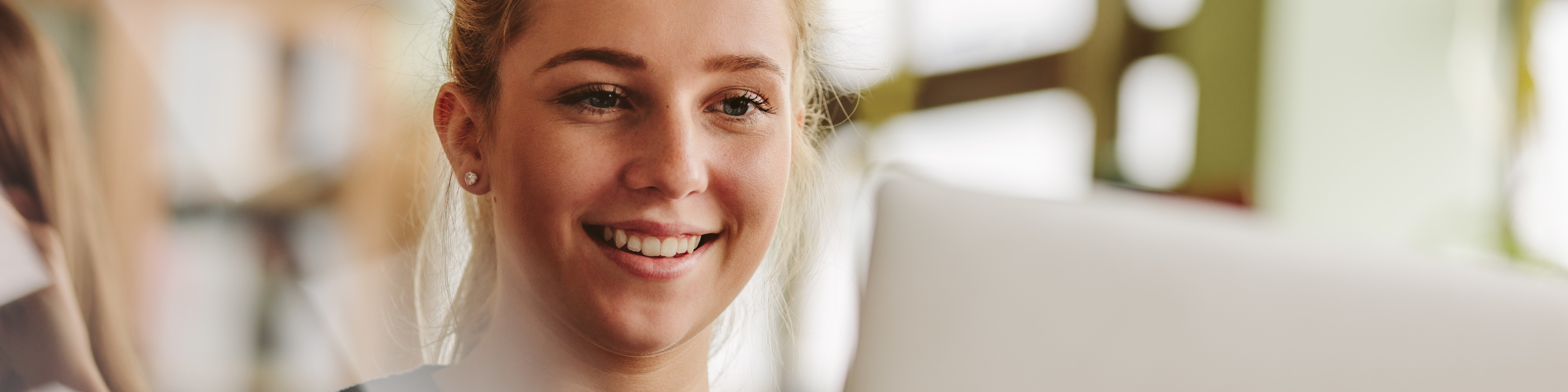 Junges Mädchen sitzt vor einem Laptop