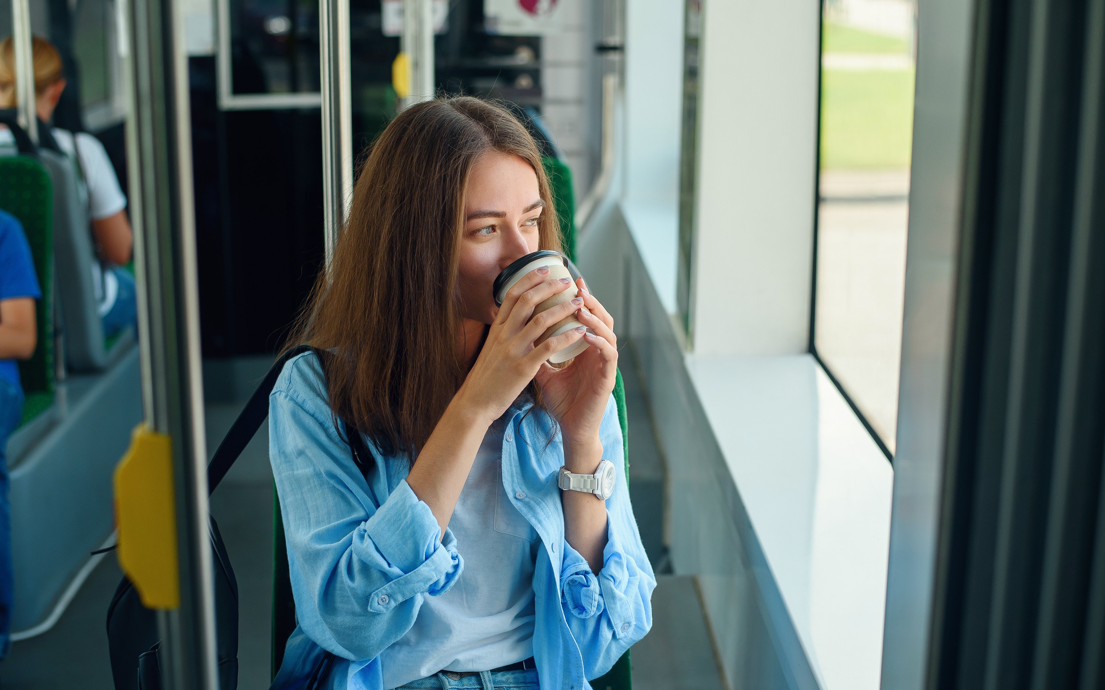 Studentin im Bus, einen Coffee to go trinkend Studentin im Bus, einen Coffee to go trinkend