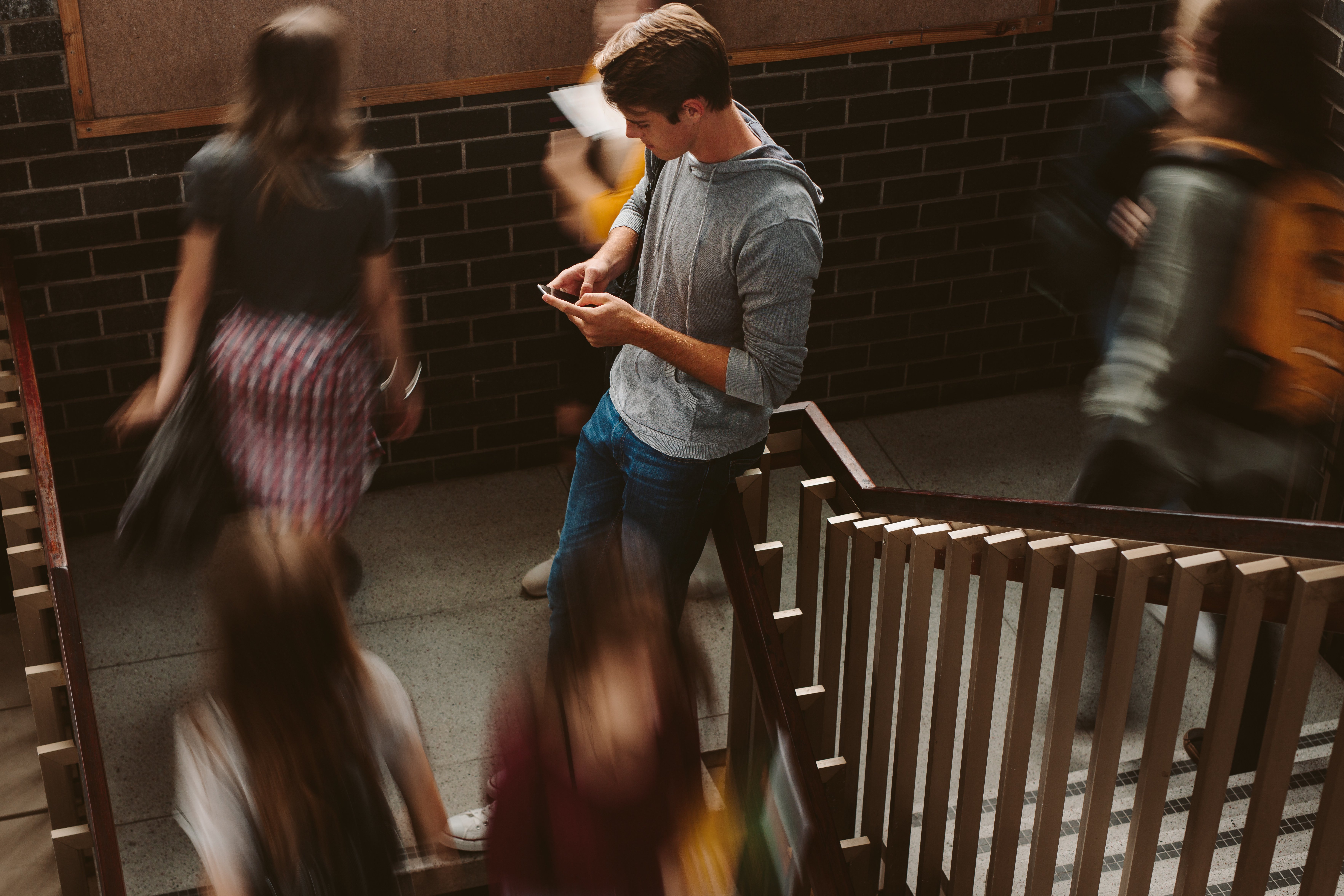Student lehnend am Treppengeländer Student lehnend am Treppengeländer