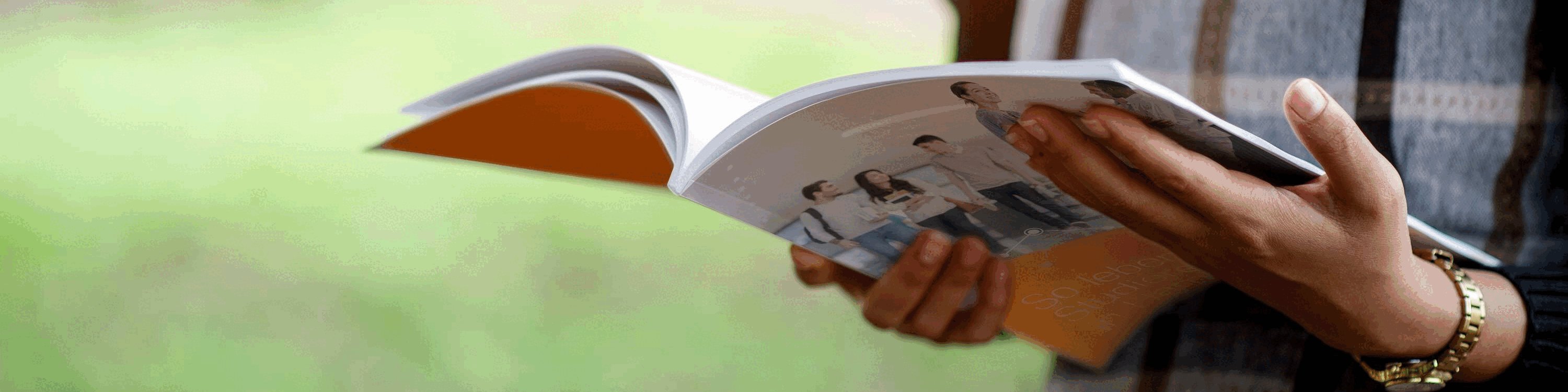 Frau im Park mit einem Magazin in den Händen