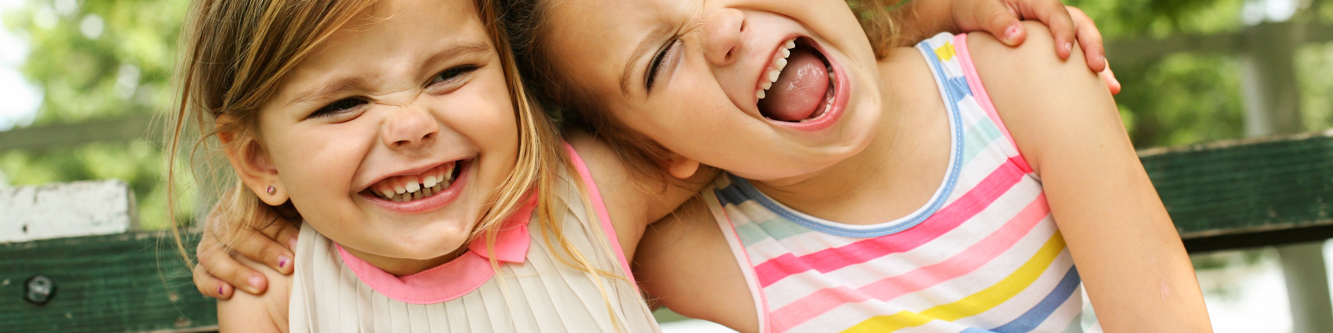 Zwei lachende Mädchen umarmen sich